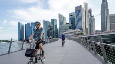 Two cyclists ride across the Jubilee Bridge in Singapore. The clean-energy push is part of Singapore’s Green Plan, that also includes measures such as planting more trees, adding electric vehicle charge points, and ceasing new registrations of diesel cars and taxis from 2025. Photo: EPA