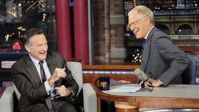 In this Wednesday, September 25, 2013 photo provided by CBS, actor Robin Williams, left, joins host David Letterman on the set. AP