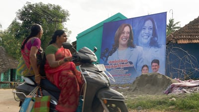 Two women on a scooter ride past the hoarding of Kamala Harris at Thulasendrapuram in Tamil Nadu in southern India. The villagers have erected the hoarding to congratulate Ms Harris who has been nominated by her Democratic Party for the top post in the upcoming election.