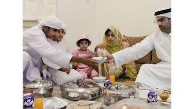 Ali Mohamed Saeed al Sudain enjoys iftar with his children, from left, Rashed, 14, Zayed, nine, Mahra, three, Owaish, 11, and Sayed, six, at their home in Al Rahba. Lauren Lancaster / The National