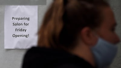 A woman walks past a hair salon ready to reopen in Arlington, Virginia. Millions of Americans are returning to work, businesses are reopening and many restaurants are once again serving dine-in customers. AFP