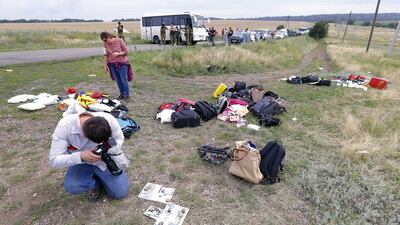 Journalists document the passengers' belongings at the main crash site of the Boeing 777 Malaysia Airlines flight MH17. EPA/ROBERT GHEMENT