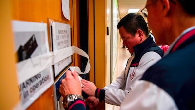 Member of a team including Poly U management, security guards, councillors and the Hong Kong Red Cross use tape to indicate not finding any remaining protesters. AFP