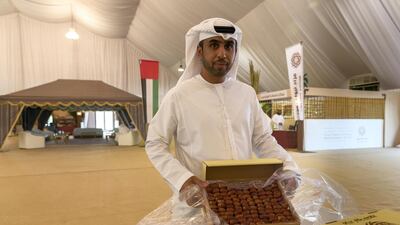 Mohammed Al Mazrouei, a date farmer, shows off his dates that were later sold at the Liwa Dat Auction. Antonie Robertson / The National
