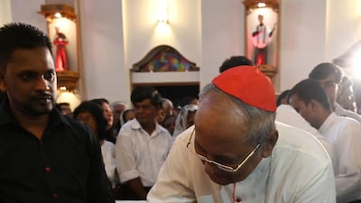 Archbishop of Colombo Malcolm Ranjith blesses a survivor of the Easter Sunday bomb attacks, at midnight mass at St. Sebastian's Church in Negombo. AFP