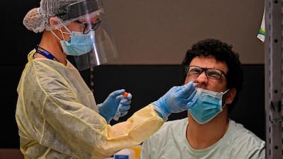 Health workers check passengers who arrived on an Emirates Airlines flight from London at Dubai International Airport amid the coronavirus Covid-19 pandemic. AFP