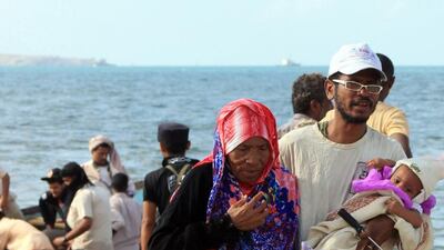 Yemenis walk on a beach in Aden's Al Tawahi neighbourhood on May 6, 2015, as civilians try to escape the ongoing fighting by sea. Saleh Al Obeidi/AFP Photo