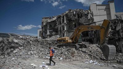 An excavator removes the rubble of collapsed buildings in the quake-hit city of Kahramanmaras, Turkey. AFP