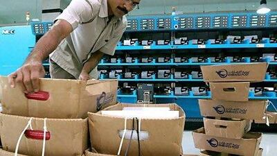 A worker arranges boxes of mail at Emirates Post office in Umm Ramool, Dubai.