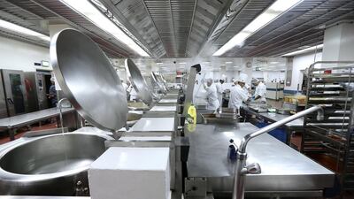 Cooks prepare food inside the kitchen at Dubai World Trade Centre in Dubai. Pawan Singh / The National