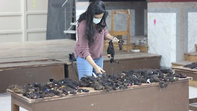 Youstina Mounir categorises the donated hair into groups based on hair type. Hasan al-Nade/The National