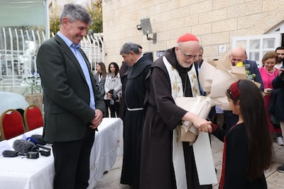 Swedish cardinal Anders Arborelius receives flowers from a girl from Gaza at the unveiling. AFP