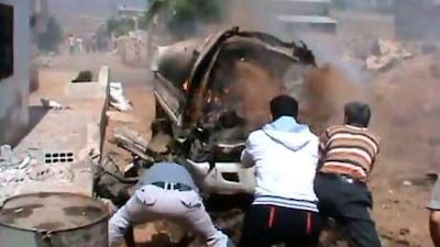 Men extinguish a burning vehicle after shelling in Deraa by Syrian government forces.