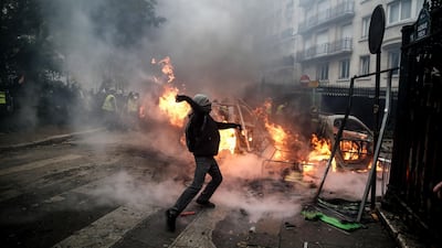 A protester throws projectile at riot police during a protest of Yellow vests in Paris. AFP