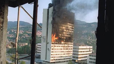 The former Parliament building in Sarajevo burns from Serbian tank fire, in September 1992, as seen from a destroyed upper floor of the Holiday Inn, where most journalists were based. Michael Evstafiev / AFP
