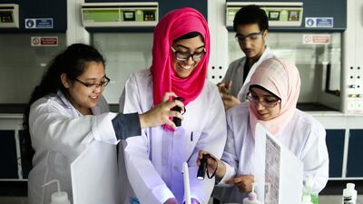 Khalifa University students being trained for Med-Camp 2014. Here Shannen Medina, Lubna Abdul Nazar and Dalia Rashed examine Lubna’s hands under a lamp to see how much bacteria is on them. Lee Hoagland / The National
