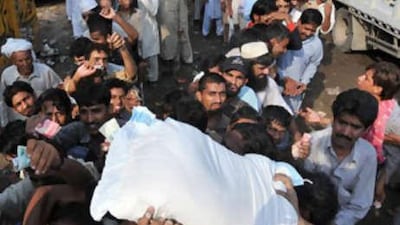 Pakistani people struggle to buy flour at state-controlled rates at the Sunday Bazaar in Lahore.