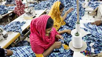 Workers sew plaid shirts on the production line of the Fashion Enterprise garment factory in Dhaka, Bangladesh. Bloomberg
