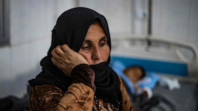 A Syrian mother sits by her child at a hospital in Hasakeh after a fire tore through a wedding party at Al Hol displacement camp. AFP