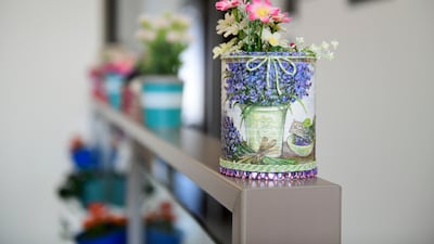 A decoupage milk powder tin doubles as a flower vase