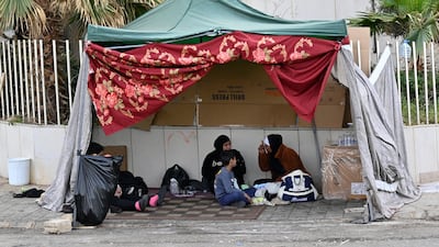 Displaced people who fled Israeli air strikes in Beirut's southern suburbs sit in a tent on Ramlet Al Bayda public beach in Beirut. EPA