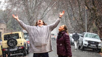 John Henning (L) and Christina Steyn (R) enjoy the rare sight of snow falling in Johannesburg as a clod front sweeps across the country's bringing sub zero temperatures, Johannesburg, South Africa, 10 July 2023. Roads had to be closed in the Eastern Cape and the SA weather service has warned that the snow in KwaZulu-Natal could also lead to road closures. Cold, wet and windy weather hit the Western Cape on 07 July afternoon and continued into 08. EPA / KIM LUDBROOK