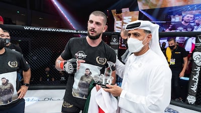 Mohammad Osseili receives the winner’s prize from Abdulmunam Al Hashemi, chairman of Palms Sports. Courtesy UAE Warriors