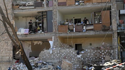 Residents of Kyiv retrieve belongings from their homes in a five-storey residential building that partially collapsed after shelling by Russian artillery. AFP
