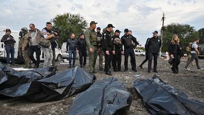 Ukrainian Interior Minister Denys Monastyrskyi stands next to the covered bodies of people killed in a Russian missile strike that hit a convoy of civilian vehicles. Reuters