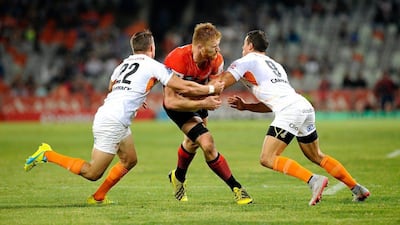 Edward Quirk of the Sunwolves tackled by Tian Meyer, left, and Shaun Venter of the Cheetahs during their Super Rugby match on Saturday. Gerhard Steenkamp / EPA