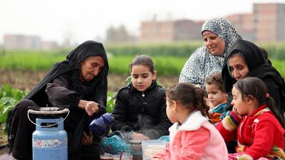 Ms Abd Elaal sits with some of her grandchildren in a field