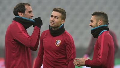 Atletico Madrid's Koke, Gabi and Diego Godin speak together during the final team training in the stadium in Munich, on December 5, 2016, on the eve of their Uefa Champions League Group D match with FC Bayern Munich. and Atletico Madrid. Christof Stache / AFP