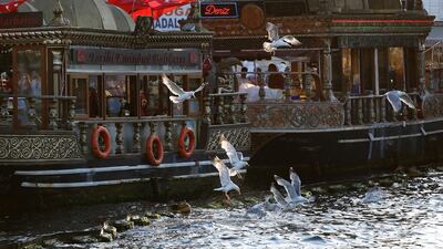 Seagulls fly by fish stalls on the Golden Horn in Istanbul. AP