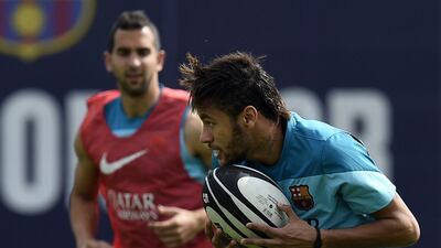 Barcelona’s Brazilian forward Neymar plays with a rugby ball during a training session at the Sports Center FC Barcelona Joan Gamper in Sant Joan Despi, near Barcelona on April 15, 2014 on the eve of their Spanish Copa del Rey final football match against Real Madrid. AFP PHOTO/ LLUIS GENE