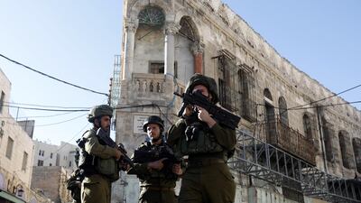 Israeli army soldiers take position during clashes with Palestinian stone throwers in Hebron. EPA