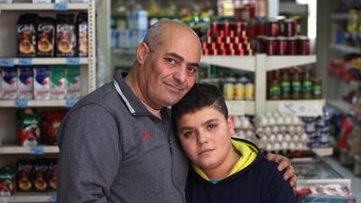 Syrian refugees Omar Al Naji and his son Abdullah, 10, in the minimarket they work at in the town of Khalde, south of Beirut. Abdullah wants to be a doctor or engineer when he grows up, but he cannot read or write and has never been to school. Mr Naji hopes to escape with his family to Europe when winter ends. Josh Wood for The National