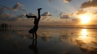 A Palestinian youth plays as the sun sets at the beach in Gaza City. Mohammed Abed / AFP