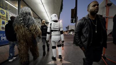Chewbacca, left, and a Stormtrooper, centre, members of the Hollywood Storm Troopers group, head home after an afternoon of posing for pictures on Hollywood Boulevard before the premiere of Star Wars: The Force Awakens at the TCL Theatre. Paul Buck / EPA