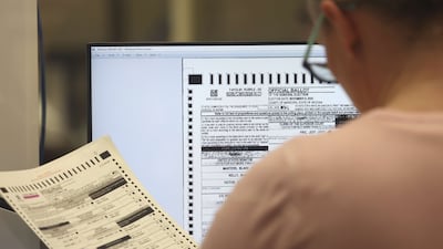 An election worker checks a ballot at the Maricopa County Tabulation and Election Centre in Phoenix, Arizona. AFP