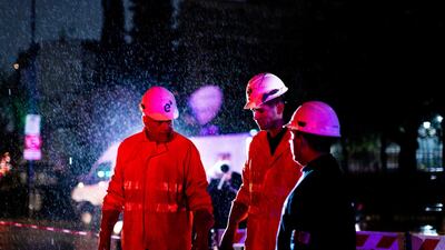 Technicians of Edenor electricity company stand under the rain as they work to fix a generator during a blackout in Buenos Aires, Argentina. AP