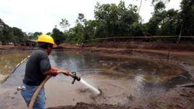 An Ecuadorean cleans up an oil waste pit. A scenario which would be revisited if drilling for oil takes place in Yasuni National Park.