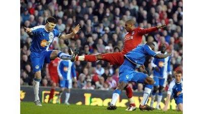 David Ngog heads the ball under pressure from the Wigan defenders.