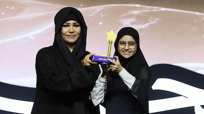 Dana Al Zarouni is presented with her trophy by Sheikha Latifa bint Mohammed, chairwoman of Dubai Culture and Arts Authority. Chris Whiteoak / The National
