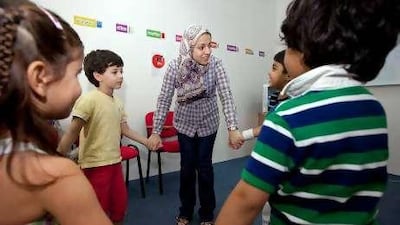 Shaima Mahmoud leads children during a word game in Arabic at the Eton Institute in Dubai.