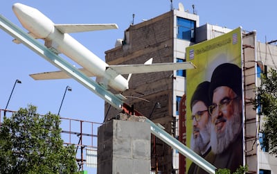 A Houthi-made mock drone is on display in front of a banner depicting portraits of late Hezbollah leaders Hassan Nasrallah and Hashem Safieddine, in Yemen. EPA