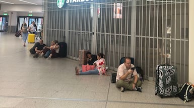 People sit outside the closed Starbucks at Gatwick airport on Sunday. PA Images
