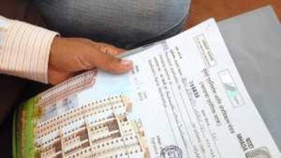Locals hold house-related lottery papers, above, as they watch the results for the MHADA lottery in Mumbai.