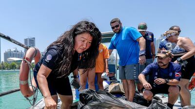 Dive volunteers with the collected bags of trash at Abu Dhabi Dhow Harbour. Victor Besa / The National
