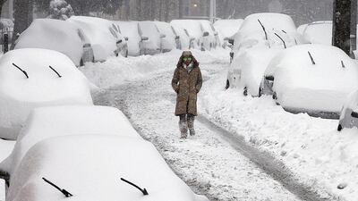 A woman walks along a street in the East Falls section of Philadelphia on as a blizzard with hurricane-force winds brought much of the East Coast to a standstill on Friday and Saturday, stranding tens of thousands of travelers. Alejandro A Alvarez/The Philadelphia Inquirer via AP