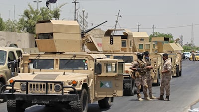 Vehicles of the Iraqi army block the entrance to the capital Baghdad's suburb of Sadr City on May 21, 2020, during a COVID-19 testing campaign. AFP